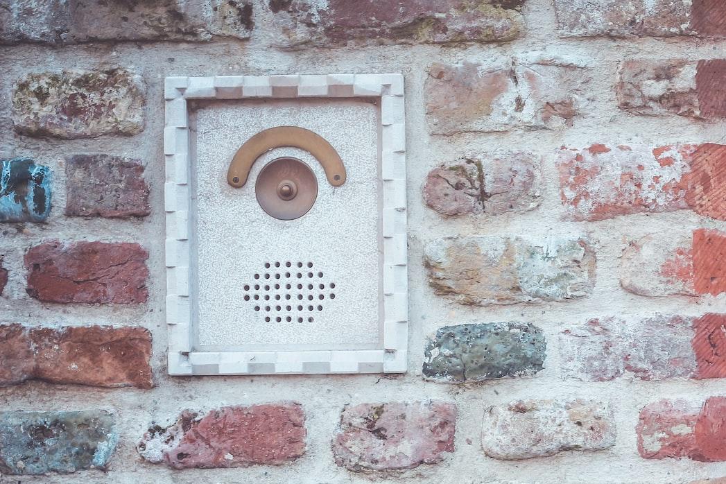 a brick wall with a red door and a red door handle